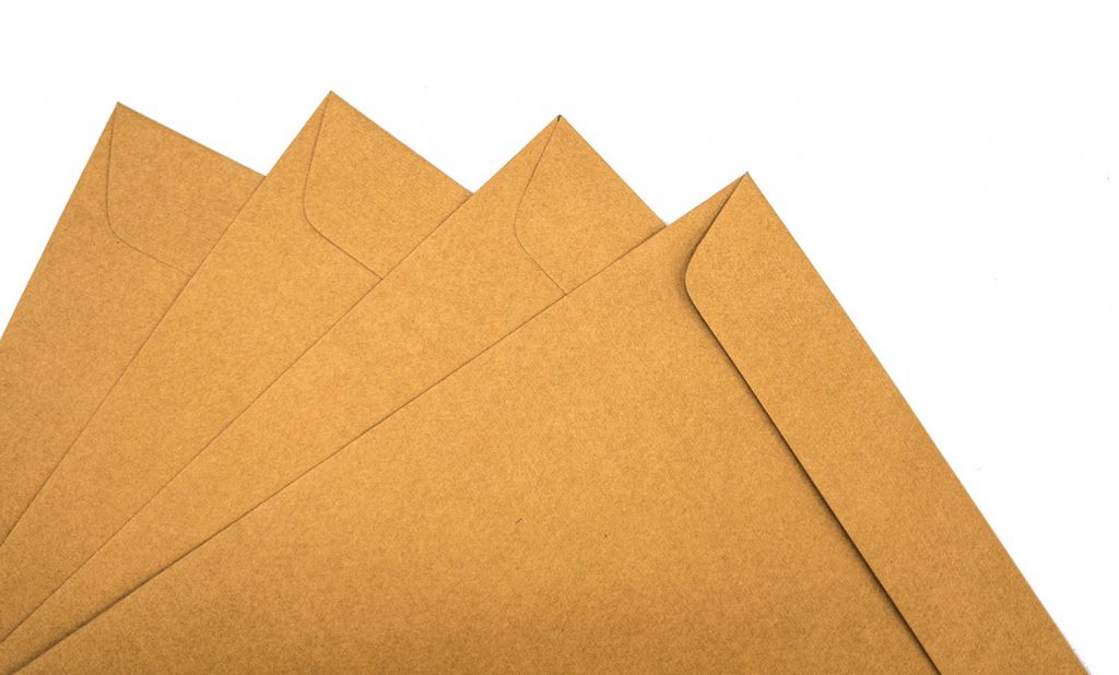 A brown envelope on a wooden floor surface, space for copy.